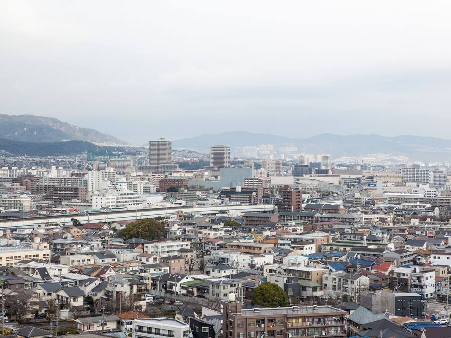 A densely packed urban area with various buildings, including residential and commercial structures, and a prominent bridge in the center.