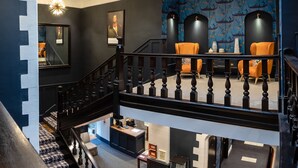 A modern hotel lobby with a staircase, a reception desk, and seating areas. - Lanelay Hall Hotel & Spa (Pontyclun)