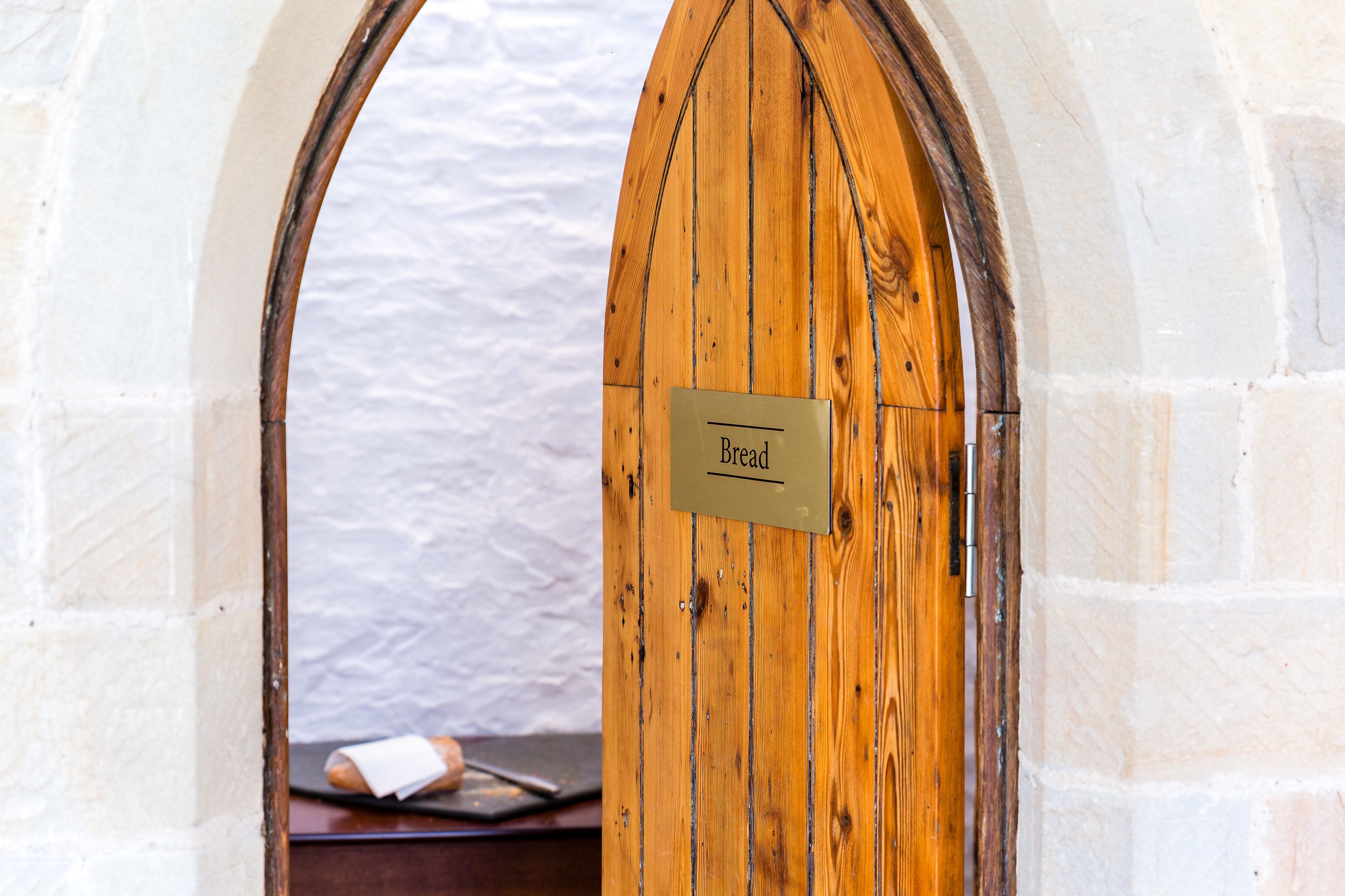 A wooden door with a sign that reads "Bread."