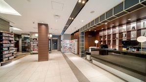 Ein modernes Interieur mit einer Rezeption, Bücherregalen und einem sauberen Fliesenboden.