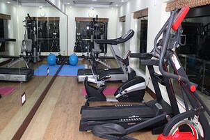 Academia com esteiras, elípticos e bolas de exercício.