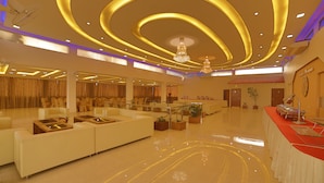 A spacious hotel lobby with a modern design, featuring a large seating area, a reception desk, and a chandelier. - Hotel Harrison Palace (Biratnagar)
