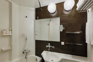 Ein modernes Badezimmer mit einem weißen Waschbecken, einem großen Spiegel und einer Duschkabine.