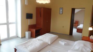 A hotel room with a bed, a wardrobe, a desk, and a chair.