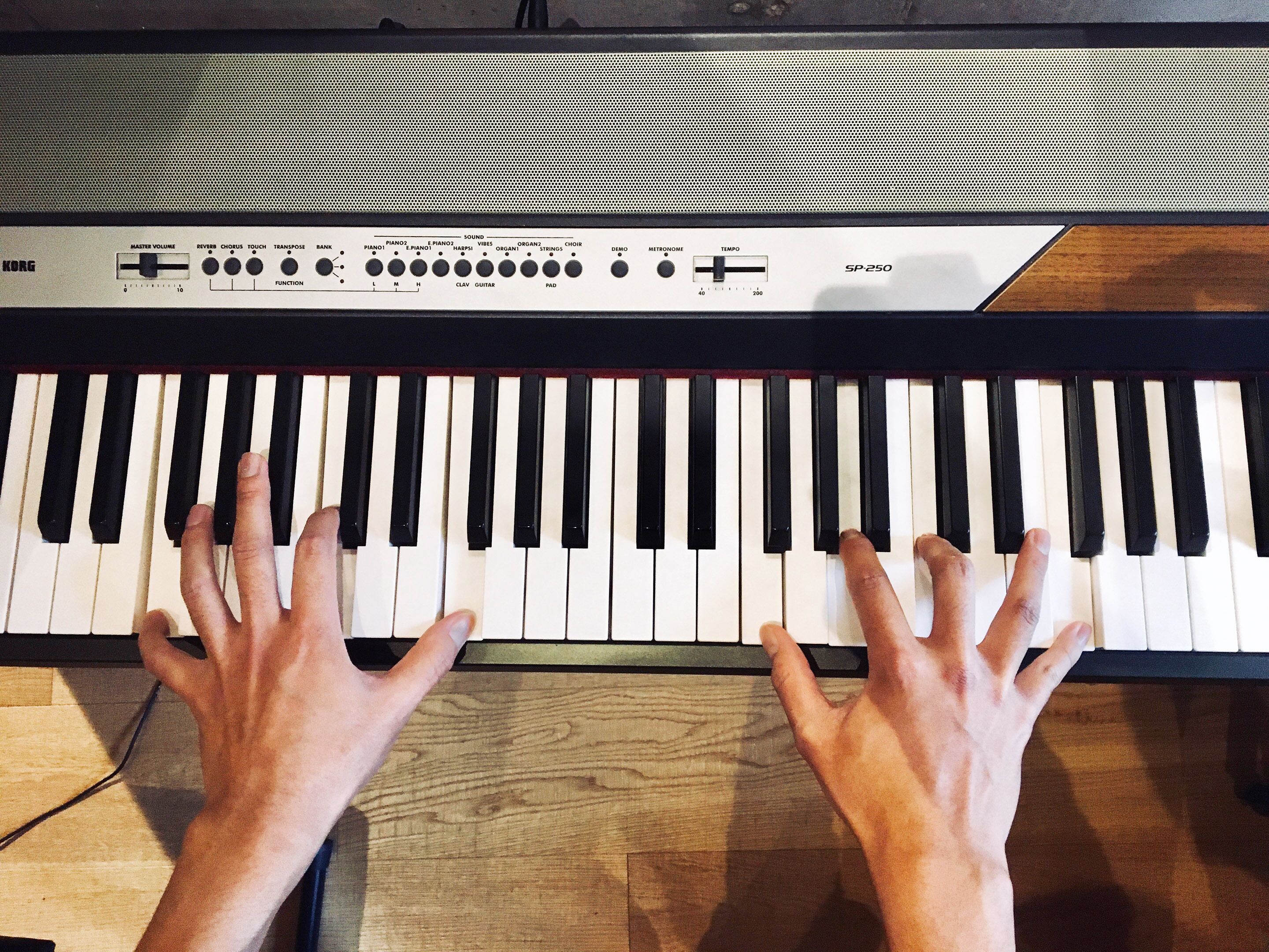 Une personne joue du clavier, et un panneau de contrôle se trouve au-dessus.