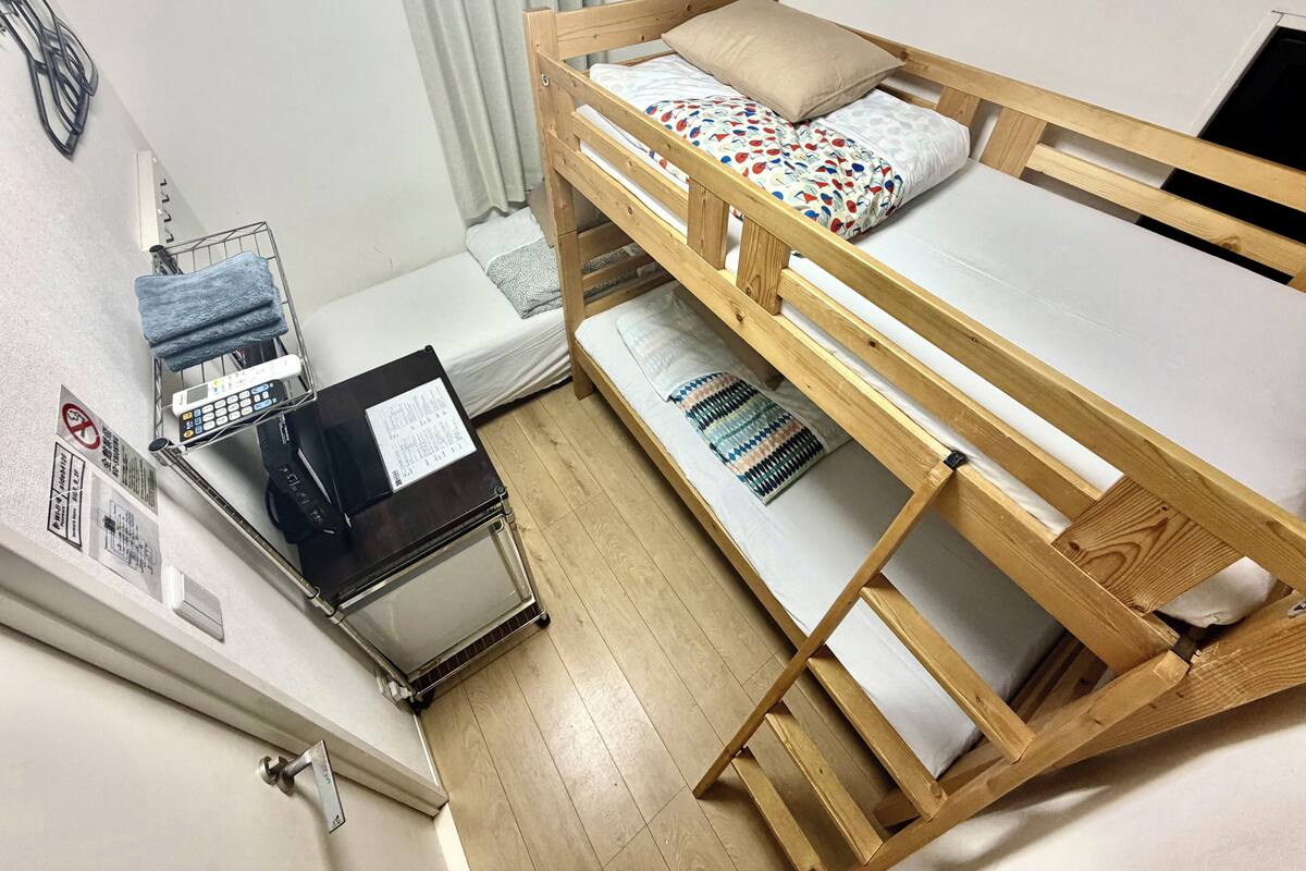 A bunk bed with a control panel and a small table with a towel.