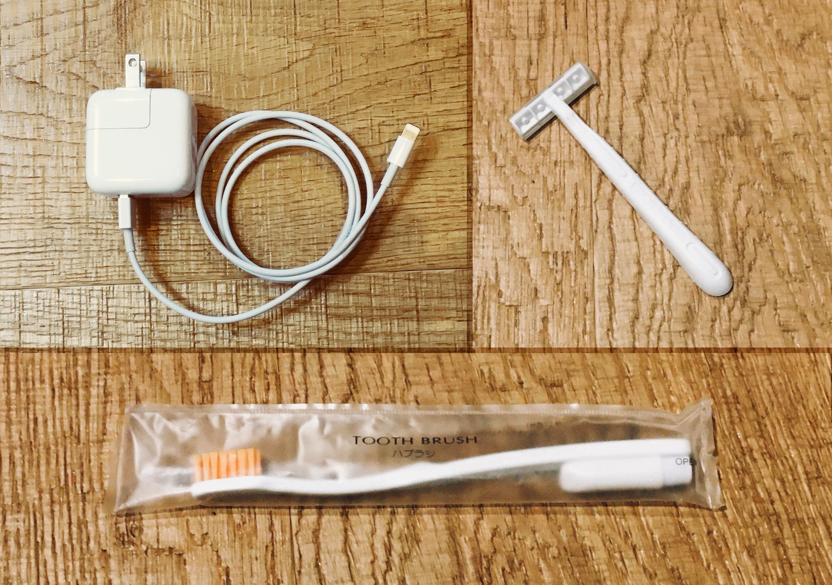 Un cepillo de dientes, un cable de carga y un cargador USB sobre una superficie de madera.