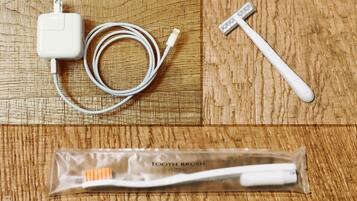 Un cepillo de dientes, un cable de carga y un cargador USB sobre una superficie de madera.