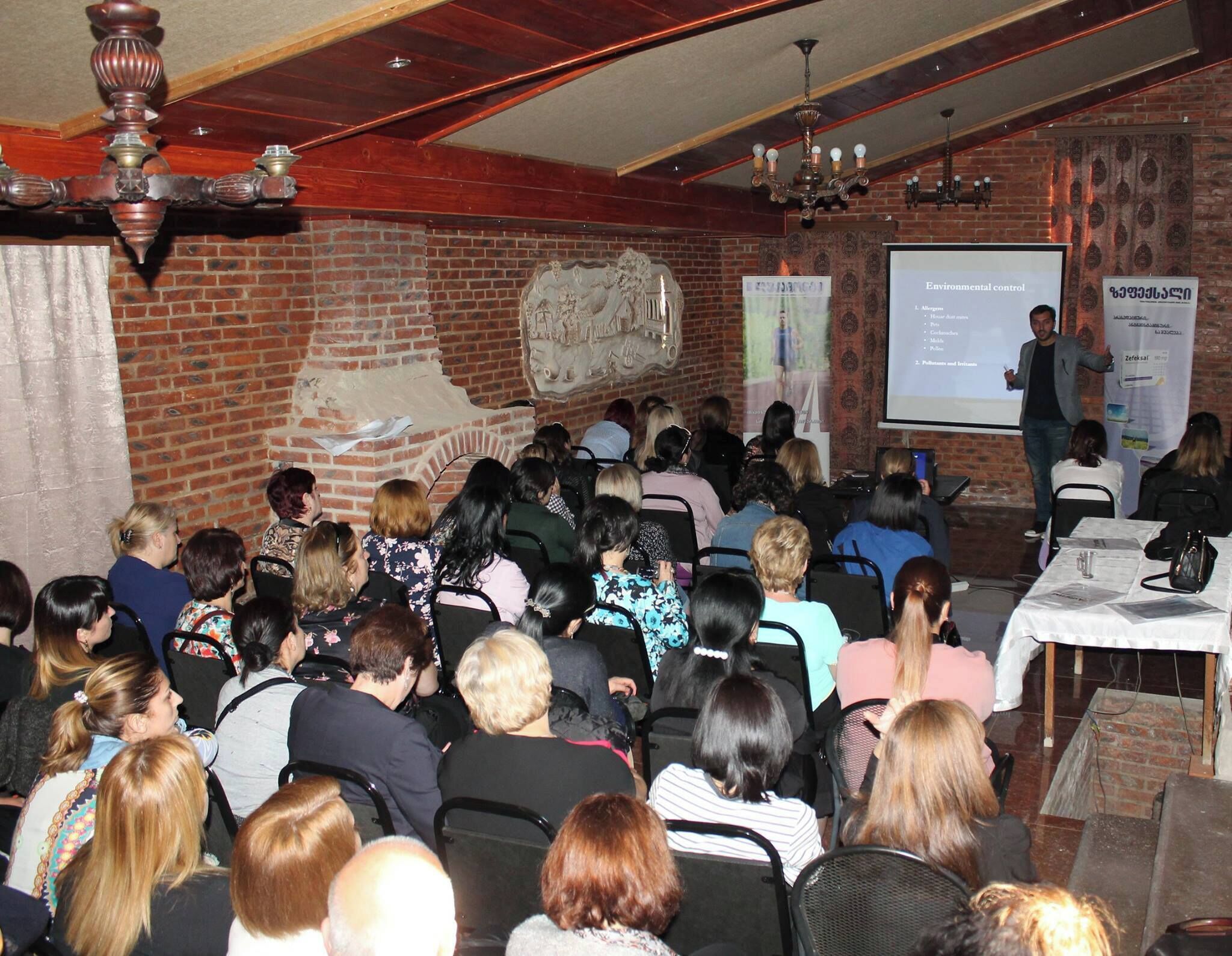 A conference room with attendees seated facing a presentation screen.