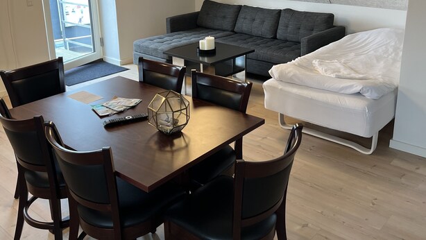 Un moderno apartamento tipo loft con zona de comedor, sofá y cama.