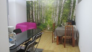 Un comedor con una mesa y sillas, una máquina de café y un sofá tapizado en rosa.
