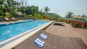 A swimming pool with lounge chairs and a deck area.