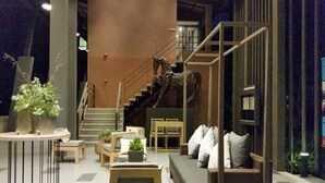 A modern interior with a staircase, seating area, and a decorative horse sculpture. - The Relaxing Room Mountain View at Baan Tew Lom Condominium Cha Am - Hua Hin (Cha-am)