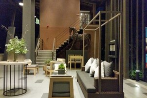 A modern interior with a staircase, seating area, and a decorative horse sculpture.