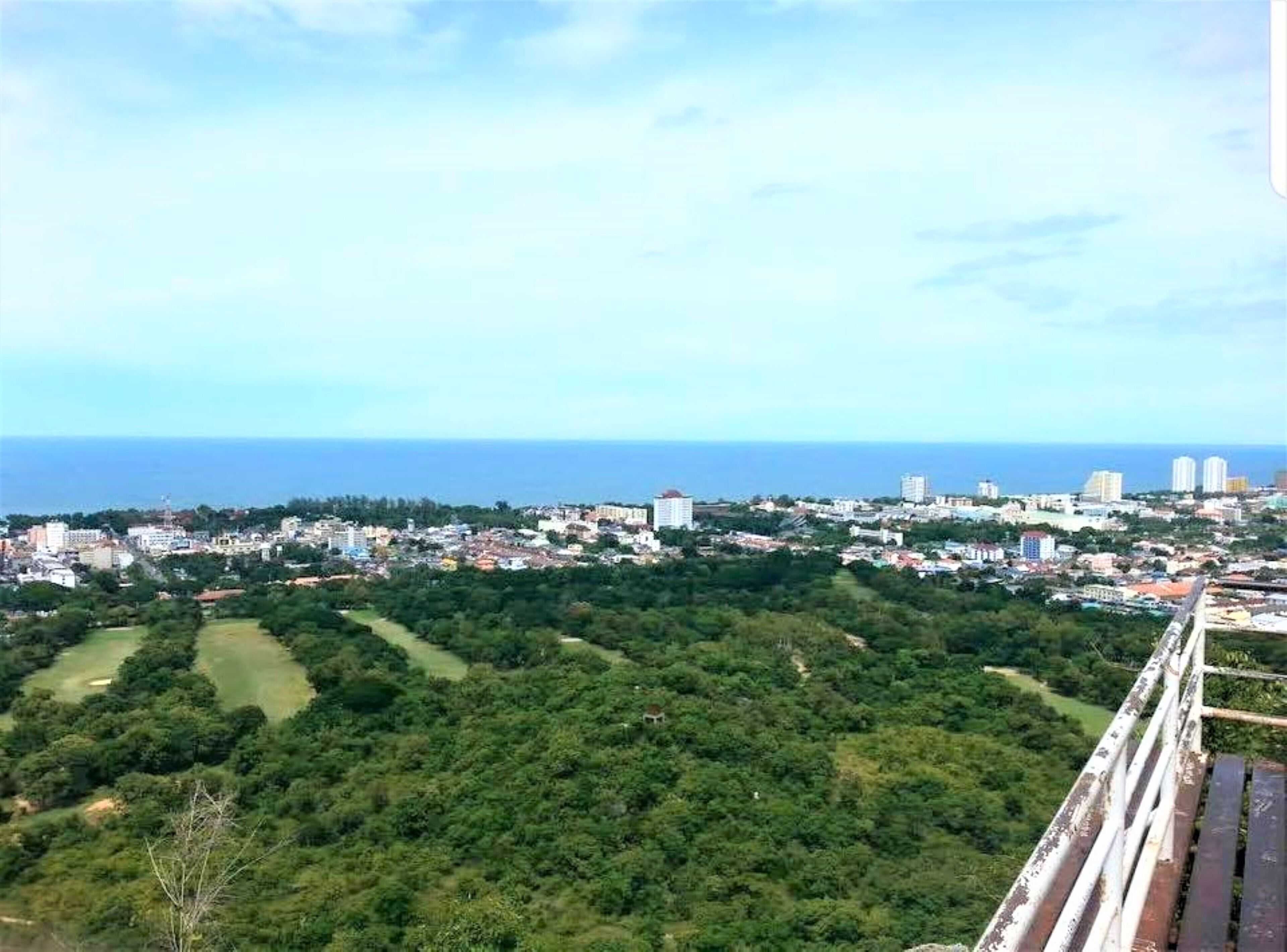 A coastal cityscape with dense urban development and a large green area in the foreground.