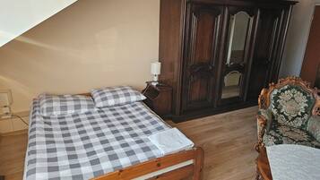 Une chambre à coucher avec un lit en bois, une table de chevet, une commode et une chaise.