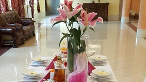 Una mesa de buffet con diversos platos, bebidas y un centro de mesa con flores.