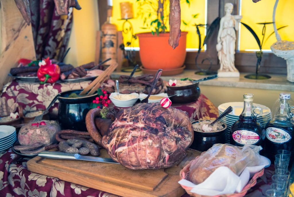 A table with various food items, including a large roasted pig, bowls, and bottles.