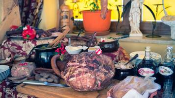 A table with various food items, including a large roasted pig, bowls, and bottles.