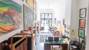 Ein geräumiger Flur mit Schreibtisch, Stühlen und Kunstwerken an den Wänden.