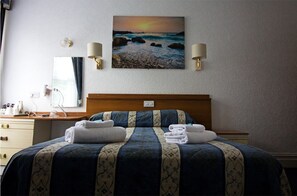 Habitación doble | Tabla de planchar con plancha y ropa de cama