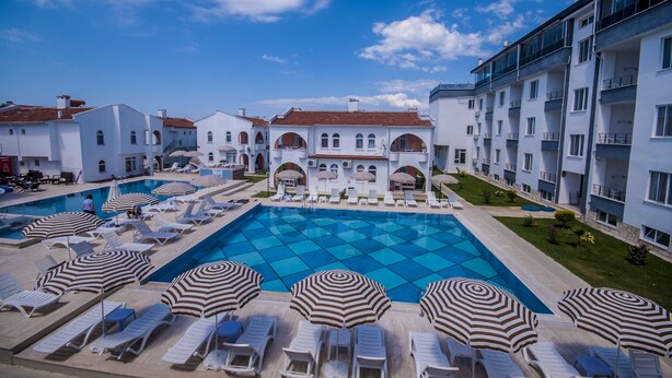 Un resort con varias piscinas, camastros y sombrillas.