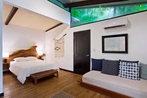 A modern hotel room with a large bed, a bench, a wall-mounted air conditioner, and a framed picture. - Isla Palenque Member of the Cayuga Collection (Boca Chica)