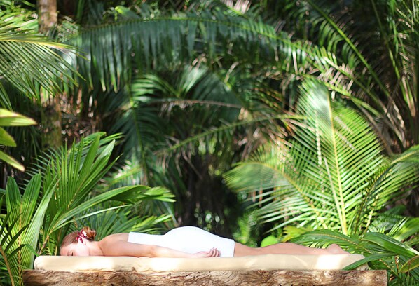 A person lying on a hammock in a lush, green environment with dense foliage. - Isla Palenque Member of the Cayuga Collection (Boca Chica)
