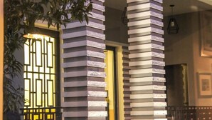 A modern building facade with vertical slats and a lit entrance. - Hotel Antigone (Tirana)