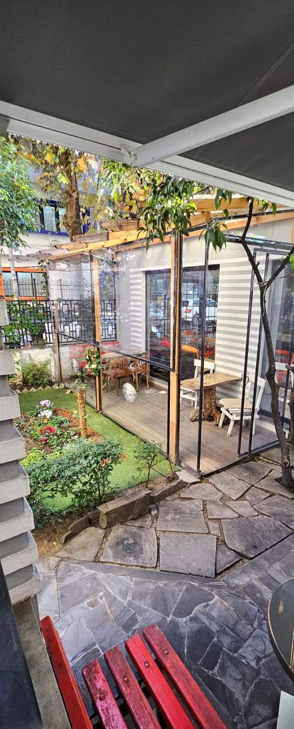 A patio area with a pergola, outdoor seating, and a garden.