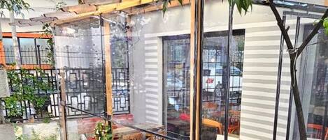 A patio area with a pergola, outdoor seating, and a garden.
