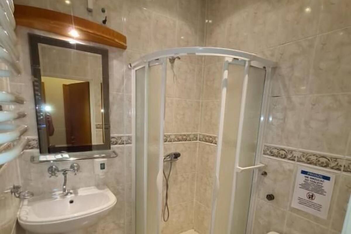 Un baño con ducha, inodoro, lavabo y espejo.
