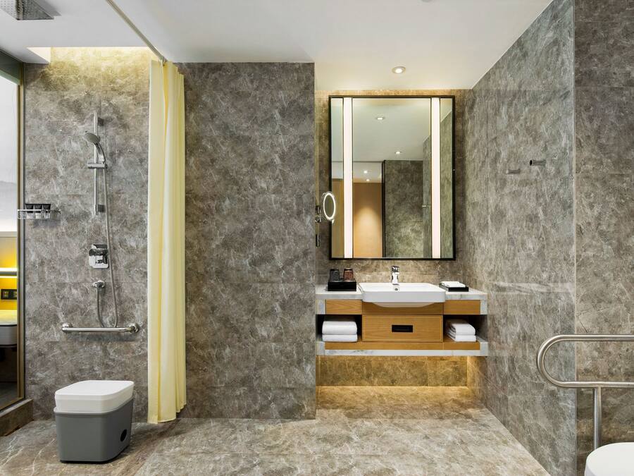 A modern bathroom with a shower, toilet, and vanity.