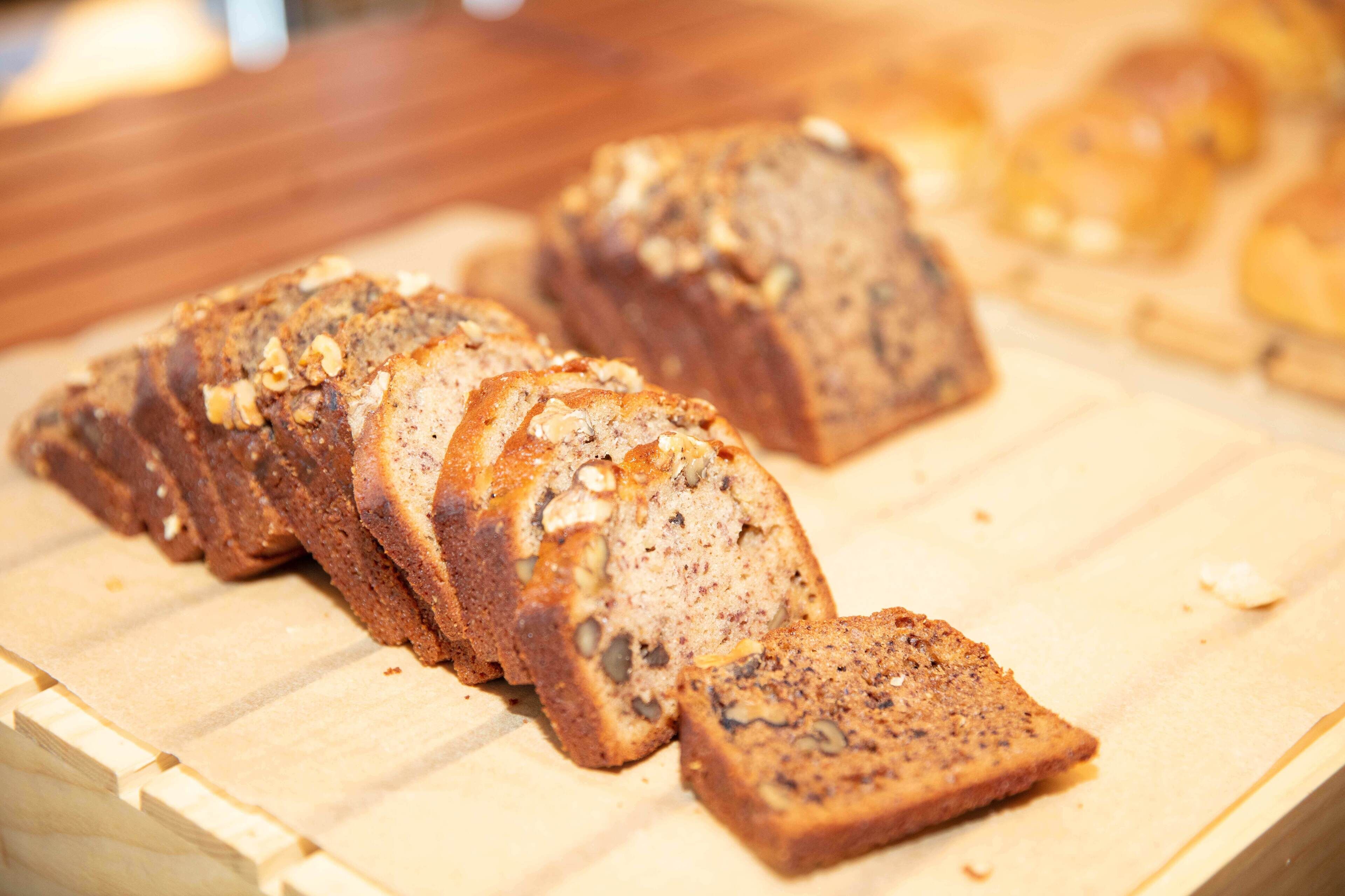 A loaf of bread with visible nuts and seeds on a wooden surface.