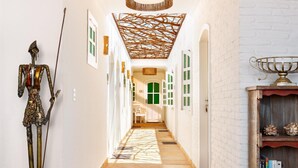 A hallway with a decorative ceiling, a statue, and a trophy on a shelf. - Pousada Monalisa (Jijoca de Jericoacoara)