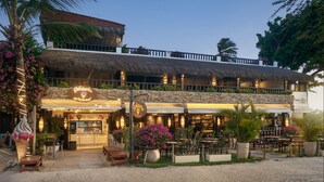 A beachfront hotel with a restaurant, outdoor seating, and a thatched-roof structure. - Pousada Monalisa (Jijoca de Jericoacoara)