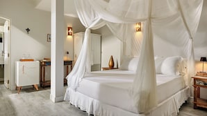A bedroom with a four-poster bed, a nightstand, a dresser, and a mirror. - Pousada Monalisa (Jijoca de Jericoacoara)