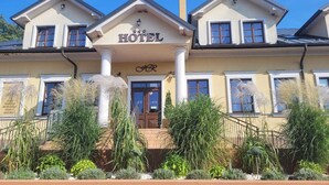 A hotel with a central entrance, columns, and a sign above the door.