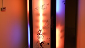 A cylindrical massage therapy room with a floral design and the words "COMETA Floral" on the wall.