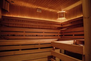 A wooden sauna with benches and a wall-mounted clock. - Hotel Rytwiany Nowy Dworek (Rytwiany)