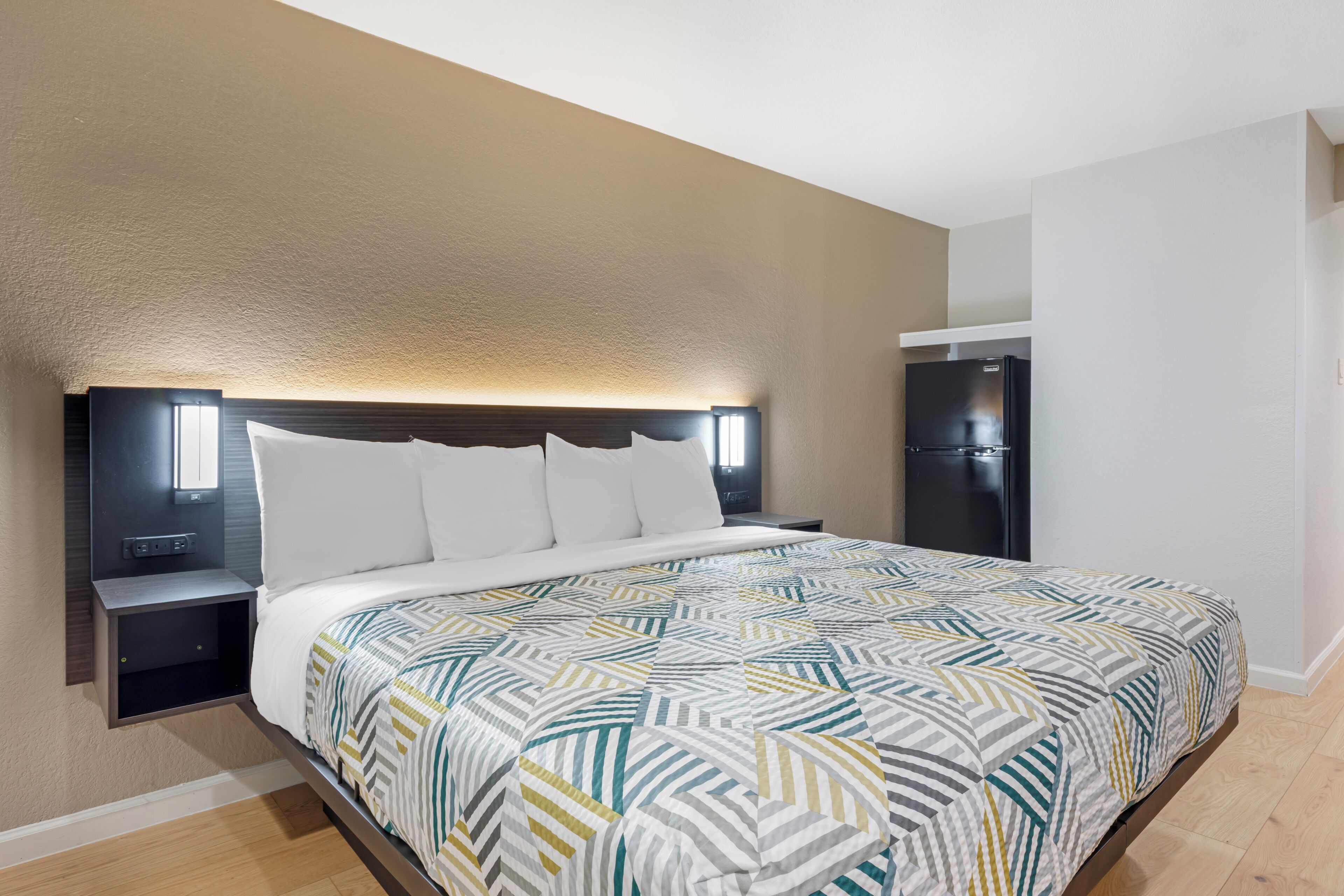 Une chambre d’hôtel équipée d’un lit, de tables de chevet, d’une armoire et d’un radiateur intégré.