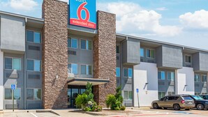 Un hotel de varios pisos con un llamativo letrero que dice 'Studio 6 Extended Stay'.
