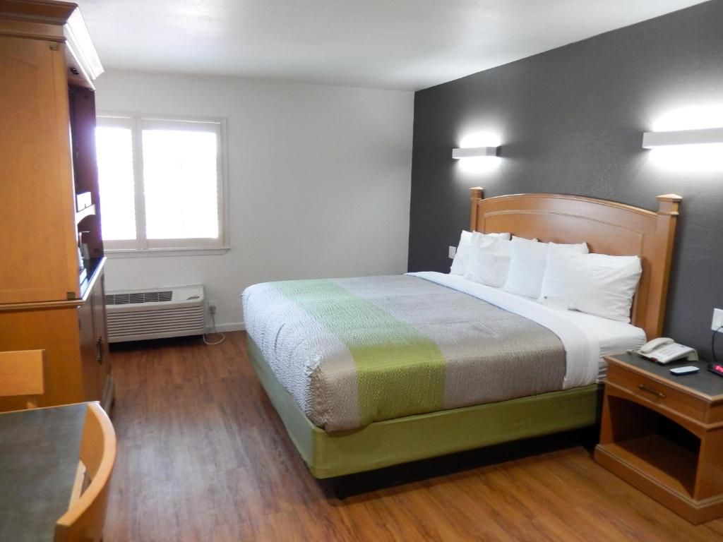 Un dormitorio con cama, mesita de noche y armario.