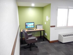 A small office space with a desk, computer, chair, and a window with blinds. - Studio 6 Plano, TX (Plano)