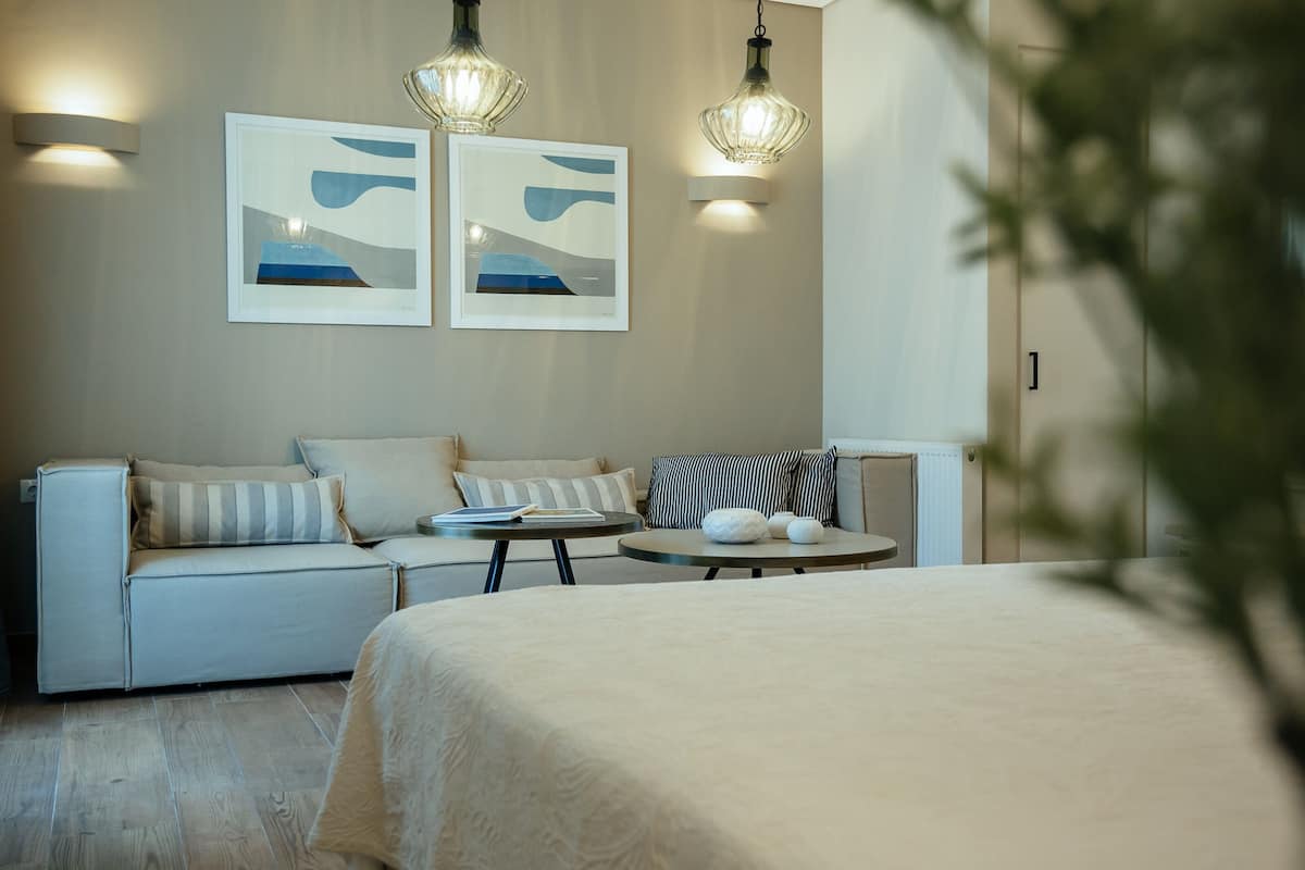 Ein modernes Hotelzimmer mit einem Bett, einer Couch, einem kleinen runden Tisch und zwei Wandleuchten.