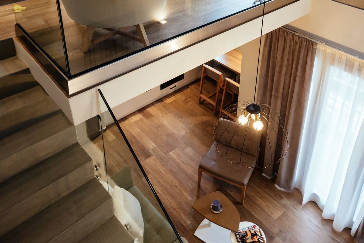 Ein modernes Schlafzimmer mit Glasdecke, einem Bett, einem Sessel und einem Schreibtisch.