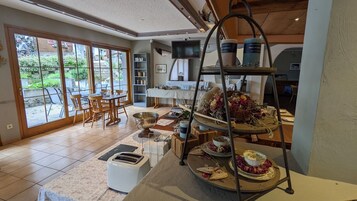 Un comedor con barra libre, un televisor y vistas al exterior a través de amplios ventanales.