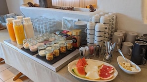 Un buffet de petit-déjeuner proposant une variété d'aliments, de boissons et d'ustensiles.