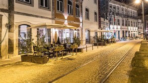 A historic building with multiple balconies and a covered outdoor seating area. - Vila Gale Porto Ribeira Hotel (Porto)