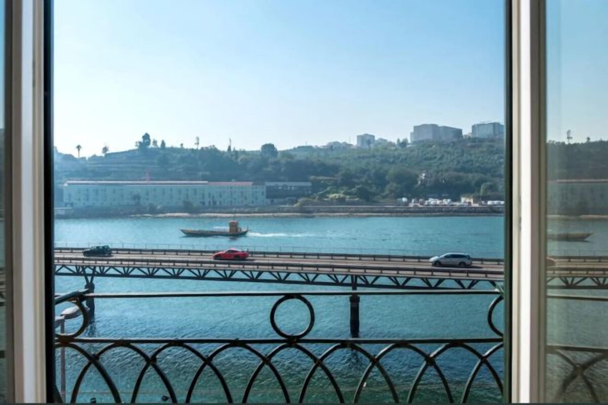 A view of a river with a bridge and buildings in the background.